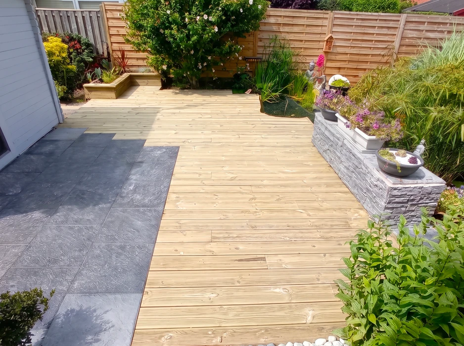 Terrasse extérieure combinant lambourdes en bois traité autoclave classe 4 et dallage en grès cérame anthracite grand format