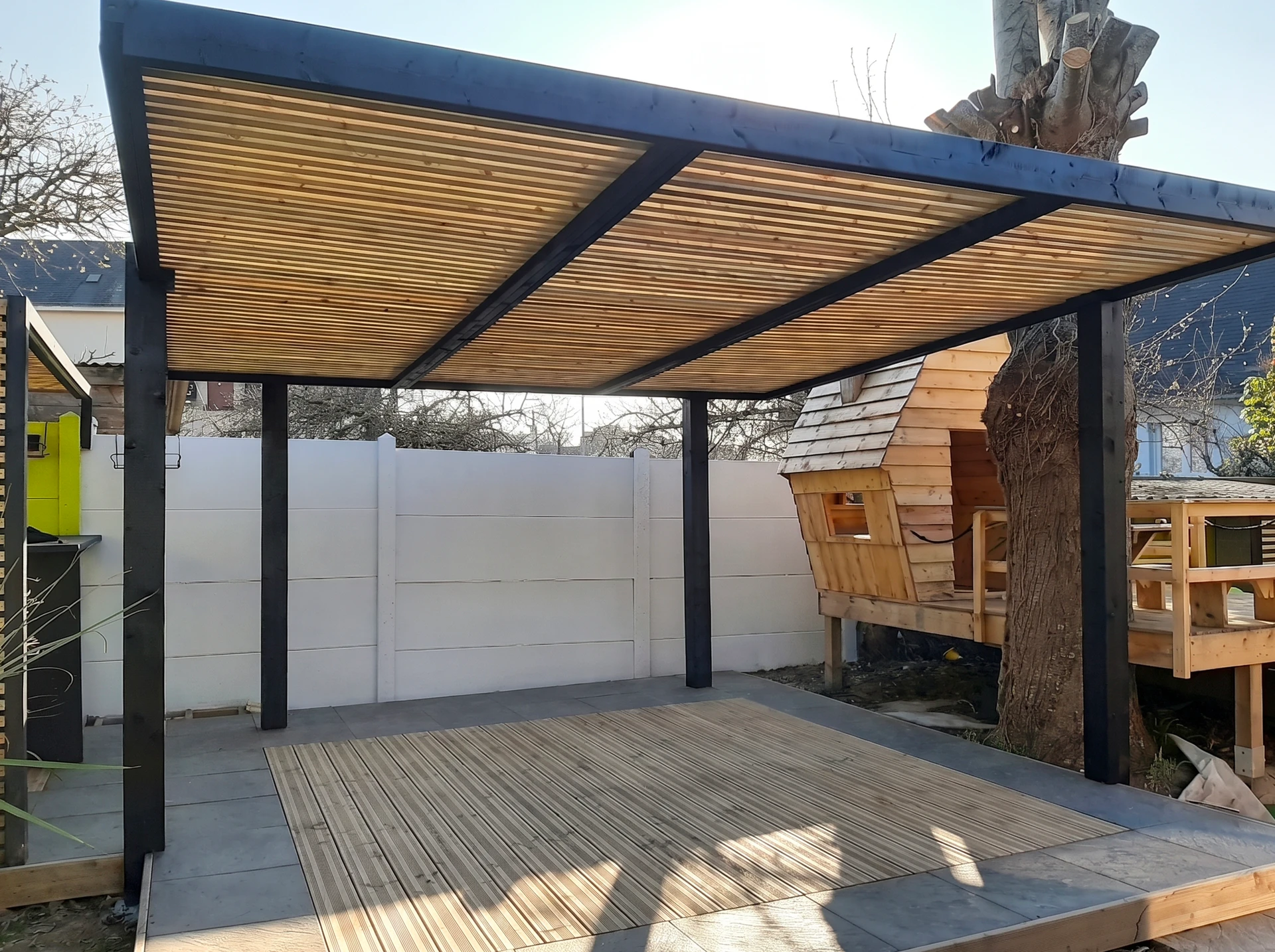 Extension moderne en bois avec bardage vertical sur maison traditionnelle en brique