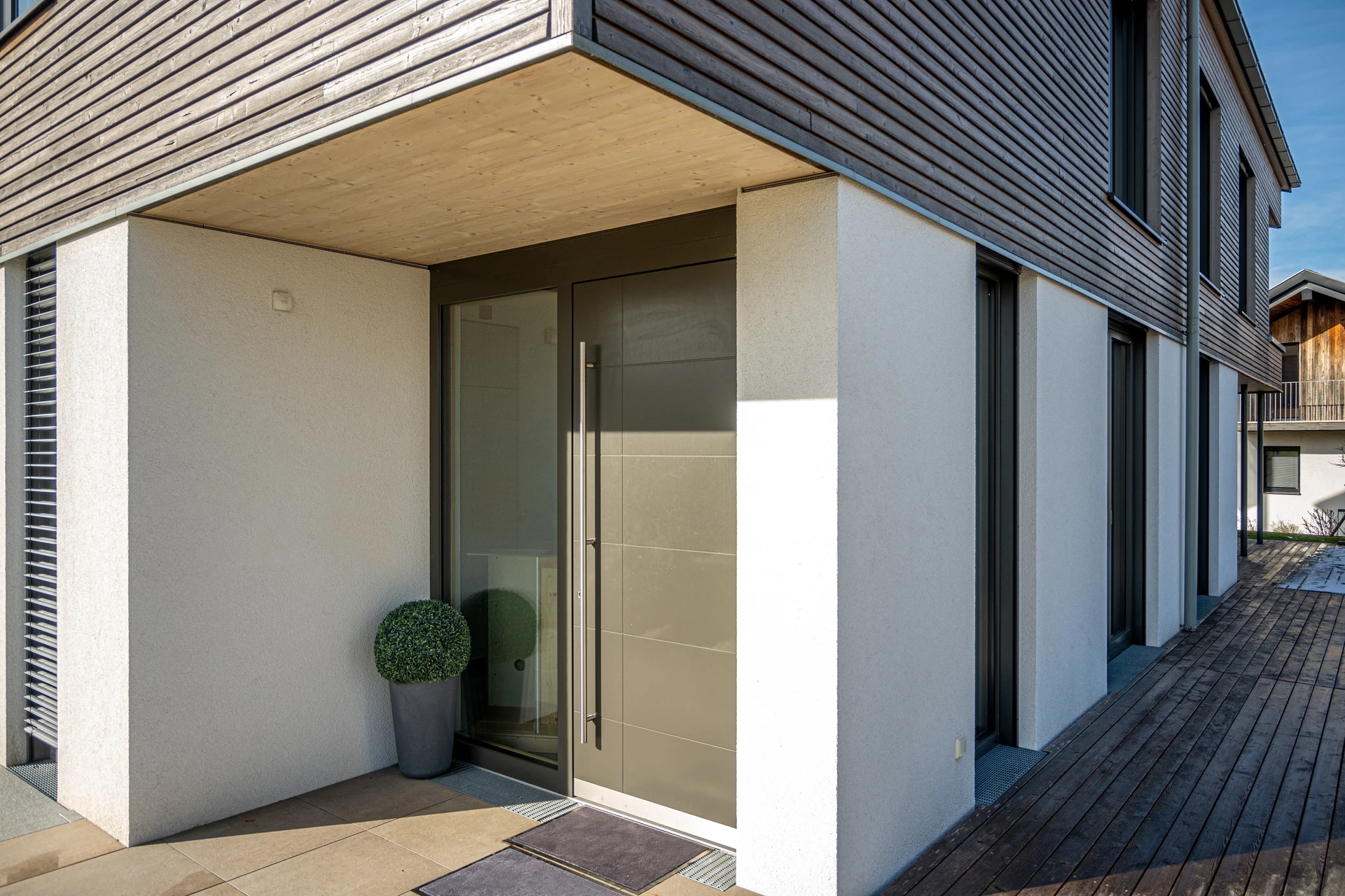 Un ouvrier installe une porte-fenêtre coulissante à châssis anthracite dans une maison en rénovation